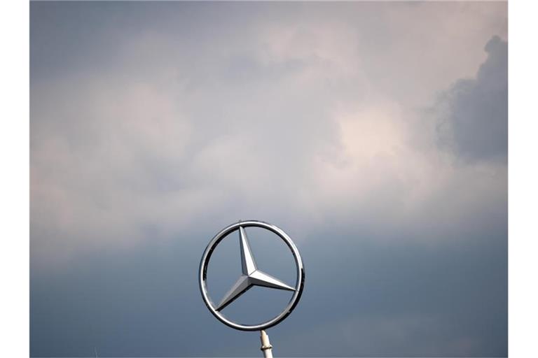 Wolken ziehen über dem Mercedes-Stern eines Werkes der Daimler AG. Foto: Federico Gambarini/dpa