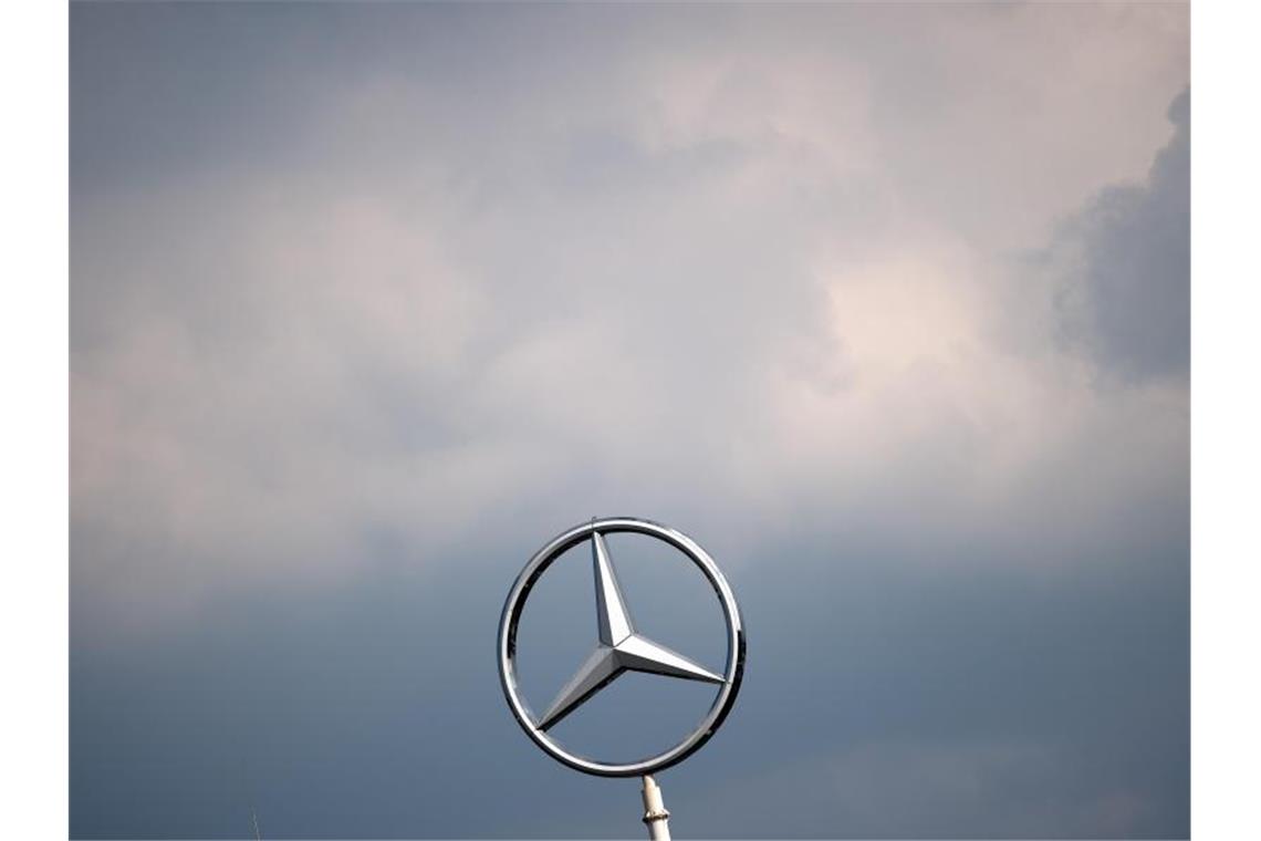 Wolken ziehen über dem Mercedes-Stern eines Werkes der Daimler AG. Foto: Federico Gambarini/dpa