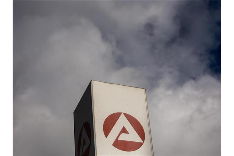 Wolken ziehen über ein Schild der Agentur für Arbeit und dem Berlin-Lichtenberg. (Archivbild). Foto: Carsten Koall/dpa