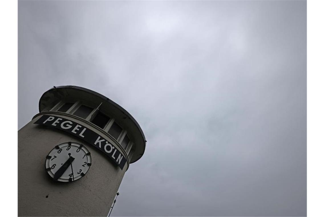 Wolken ziehen über eine Pegeluhr in Köln hinweg. In Nordrhein-Westfalen drohen in den nächsten Tagen Gewitter und Schauer. Foto: Oliver Berg/dpa