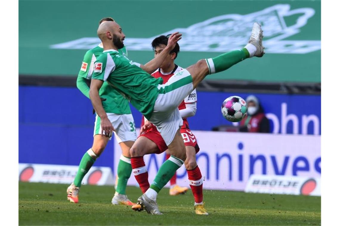 Woo-Yeong Jeong (r) konnte mit Freiburg einen Punkt aus Bremen (hier Ömer Toprak) mit nach Hause nehmen. Foto: Carmen Jaspersen/dpa