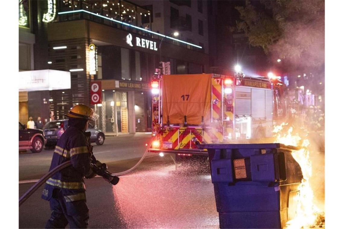 Proteste in Minneapolis nach Tod von Afroamerikaner Wütende Menschen, brennende Mülltonnen: Erneut ist in Minneapolis eine Polizeiaktion tödlich eskaliert - hier war vor einem Jahr der Afroamerikaner George Floyd bei einem Einsatz ums Leben gekommen. Foto: Christian Monterrosa/FR171731 AP/dpa