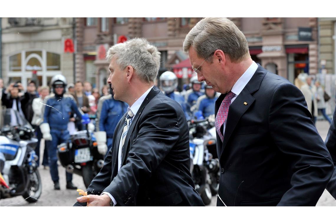 Als Politiker mit Lebensmitteln und Farbe attackiert wurden Wulff (r) ist nicht der Einzige, der im April 2011 getroffen wird. (Archivbild)