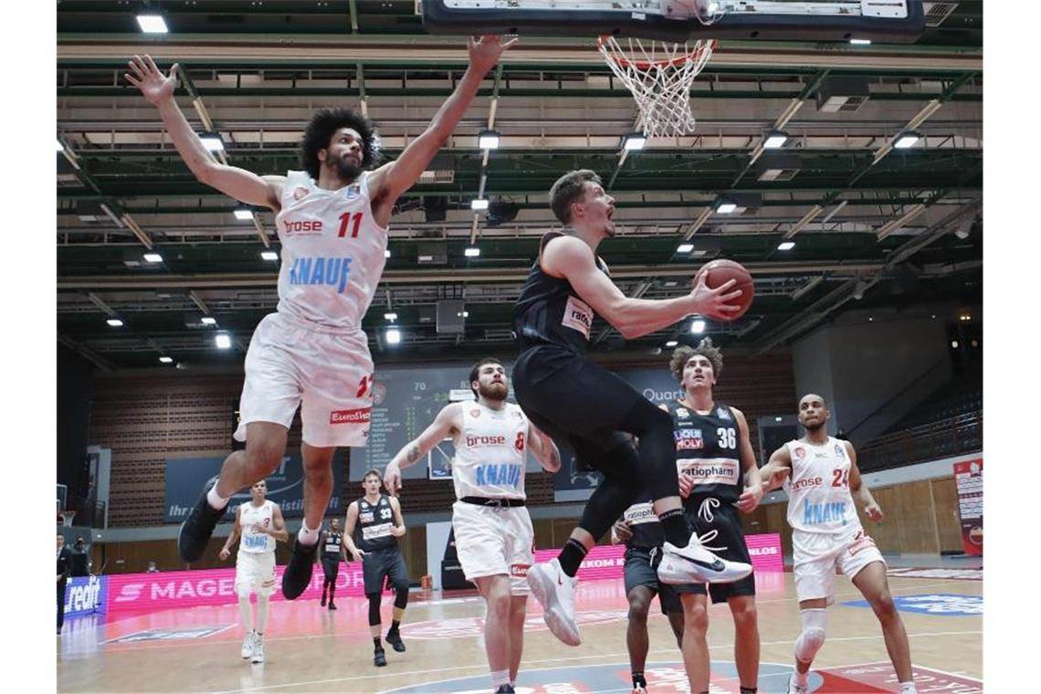 Ulms Basketballer starten mit Sieg in neue Saison Zach Smith (l) von Würzburg und Andreas Obst von Ulm in Aktion. Foto: Heiko Becker/HMB Media/POOL/dpa