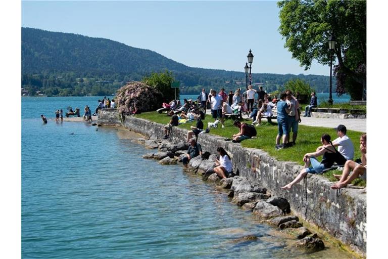 Zahlreiche Ausflügler genießen das schöne Wetter am Ufer des Tegernsees in Bayern. Foto: Sven Hoppe/dpa