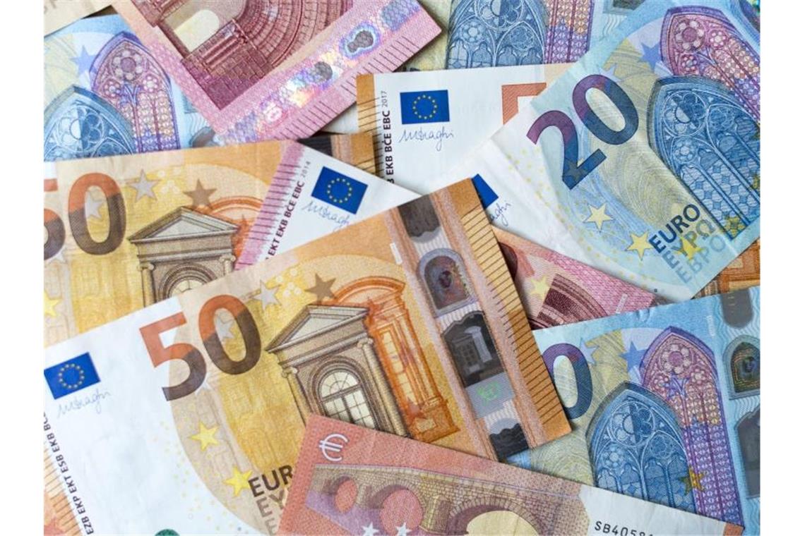 Zahlreiche Banknoten von 10, 20 und 50 Euro liegen auf einem Tisch. Foto: Monika Skolimowska/Archivbild