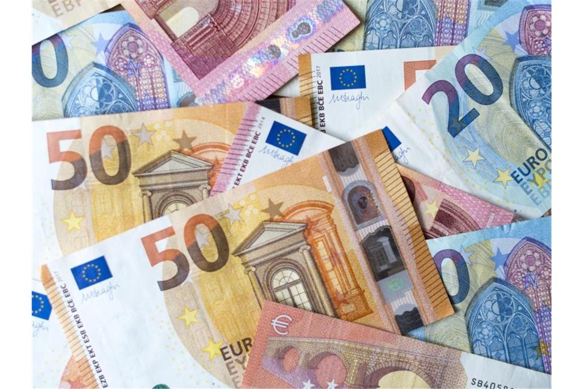 Zahlreiche Banknoten zu 10, 20 und 50 Euro liegen auf einem Tisch. Foto: Monika Skolimowska/dpa-Zentralbild/dpa/Illustration
