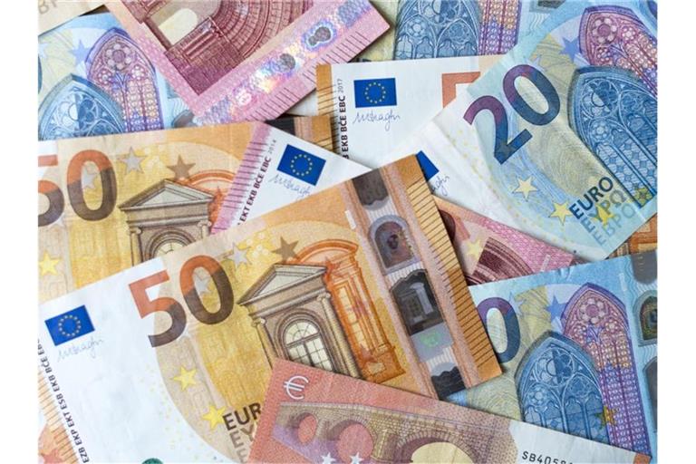 Zahlreiche Banknoten zu 10, 20 und 50 Euro liegen auf einem Tisch. Foto: Monika Skolimowska/dpa-Zentralbild/dpa/Illustration