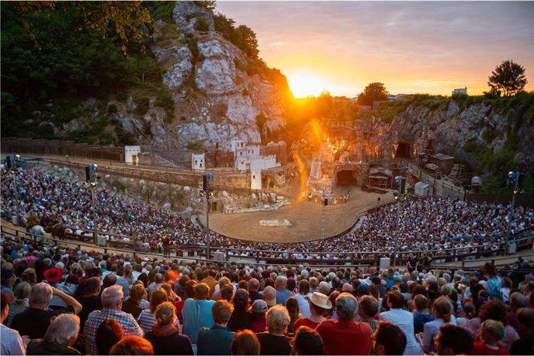 Zahlreiche Besucher verfolgen eine Aufführung der Karl-May-Spiele in Bad Segeberg vor dem Kalkberg neben der untergehenden Sonne. Seit 1952 werden im Kalkbergstadion von Bad Segeberg Karl Mays Abenteuerromane auf die Bühne gebracht.