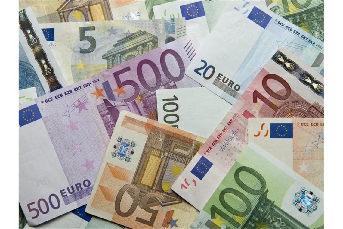 Zahlreiche Euro-Banknoten liegen auf einem Haufen. Foto: Daniel Reinhardt/dpa/Archivbild