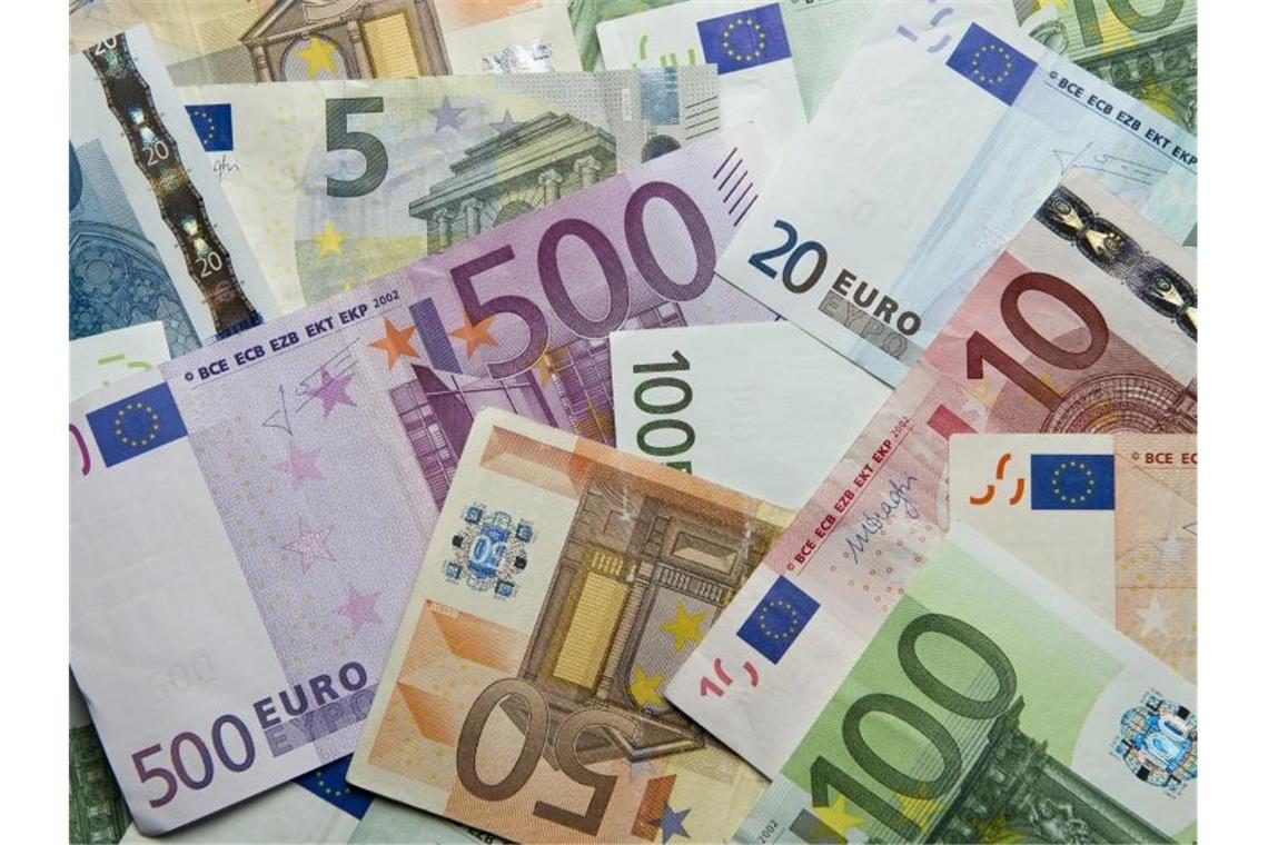 Zahlreiche Euro-Banknoten liegen auf einem Haufen. Foto: Daniel Reinhardt/dpa/Archivbild