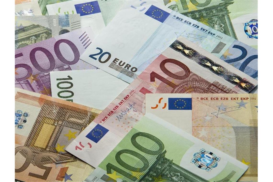 Zahlreiche Euro-Banknoten liegen auf einem Haufen. Foto: Daniel Reinhardt/dpa/Illustration