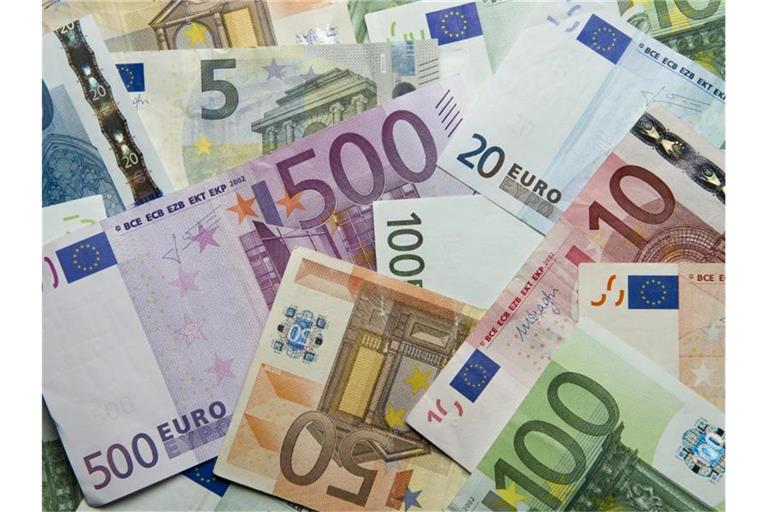 Zahlreiche Euro-Banknoten liegen auf einem Haufen. Foto: Daniel Reinhardt/dpa/Archivbild