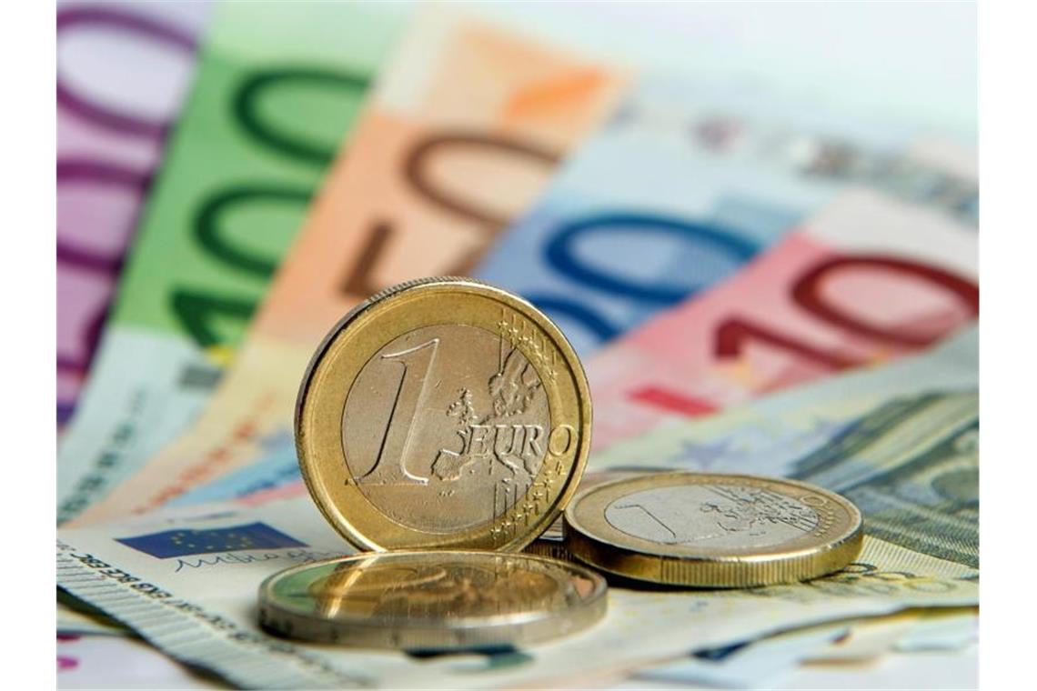 Verdienste der Arbeitnehmer 2018 leicht gestiegen Zahlreiche Euro-Banknoten und Euromünzen. Foto: Daniel Reinhardt/Archivbild
