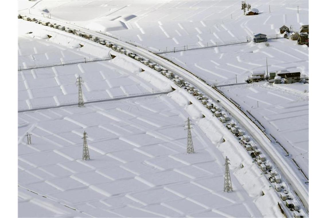 Zahlreiche Fahrzeuge stecken auf einer Schnellstraße bei Minamiuonuma im Schnee fest. Foto: -/kyodo/dpa