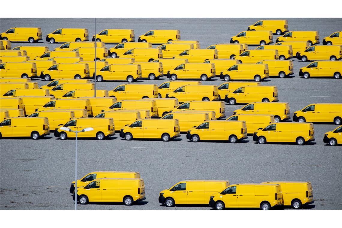 Zahlreiche gelbe Neufahrzeuge vom Typ Volkswagen T7 für die Deutsche Post stehen auf einem Gelände am JadeWeserPort in Wilhelmshaven und werden dort vor Auslieferung zwischengelagert.