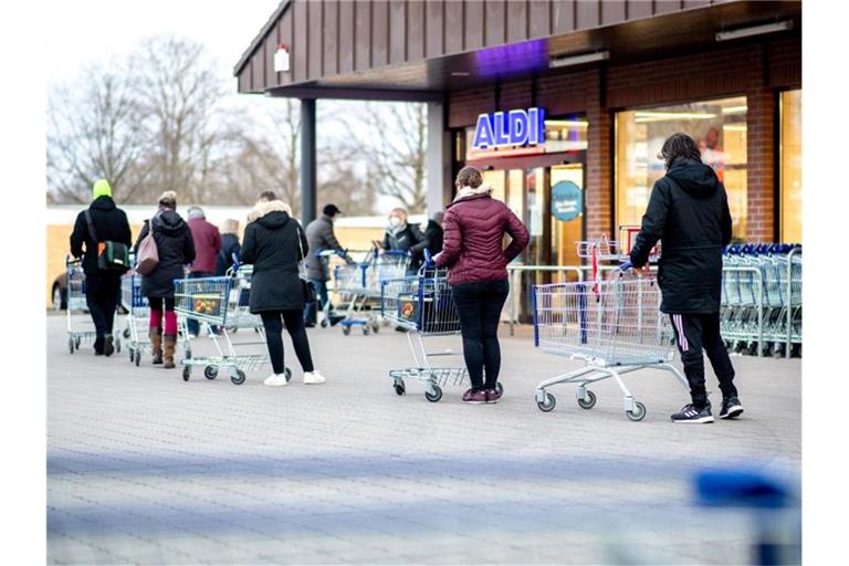 Zahlreiche Kunden warten auf die Öffnung einer Filiale von Aldi in Hannover. Der Discounter bietet nun Corona-Schnelltests zu Verkauf an. Foto: Hauke-Christian Dittrich/dpa