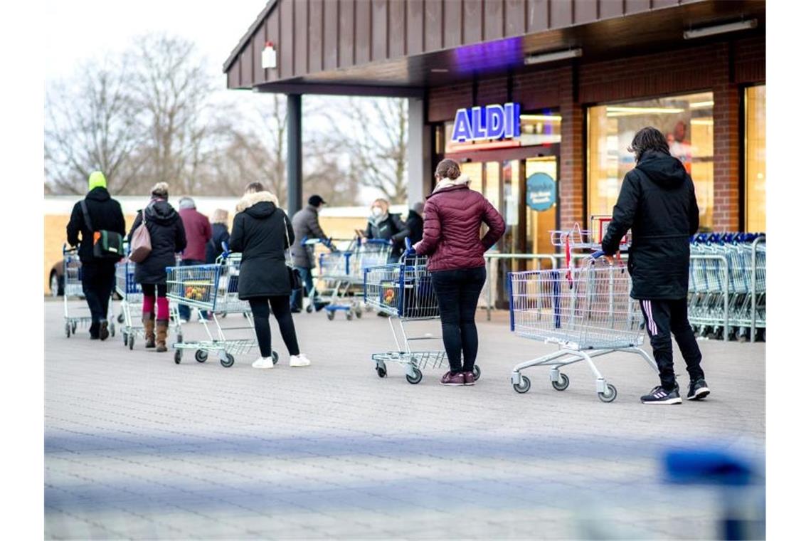 Lockdown über Ostern: Handel befürchtet lange Schlangen Zahlreiche Kunden warten auf die Öffnung einer Filiale von Aldi in Hannover. Foto: Hauke-Christian Dittrich/dpa