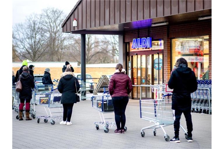 Zahlreiche Kunden warten auf die Öffnung einer Filiale von Aldi im Stadtteil Bult in Hannover. Foto: Hauke-Christian Dittrich/dpa