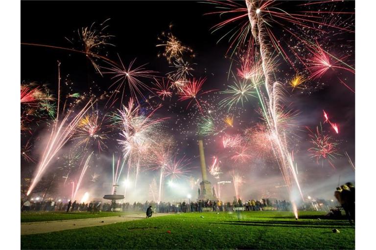 Zahlreiche Menschen feiern auf dem Schlossplatz mit reichlich Feuerwerk in das neue Jahr. Foto: Christoph Schmidt/dpa