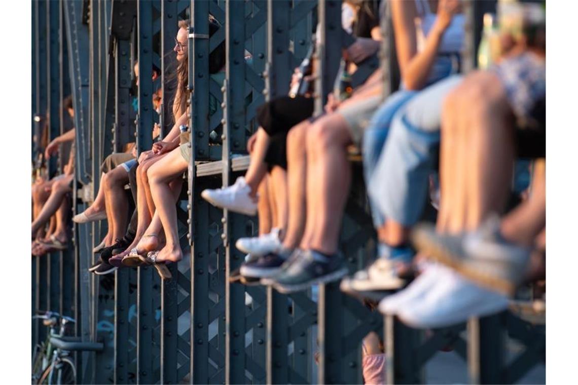 Zahlreiche Menschen genießen das schöne Wetter auf der Hackerbrücke in München. Foto: Sven Hoppe/dpa