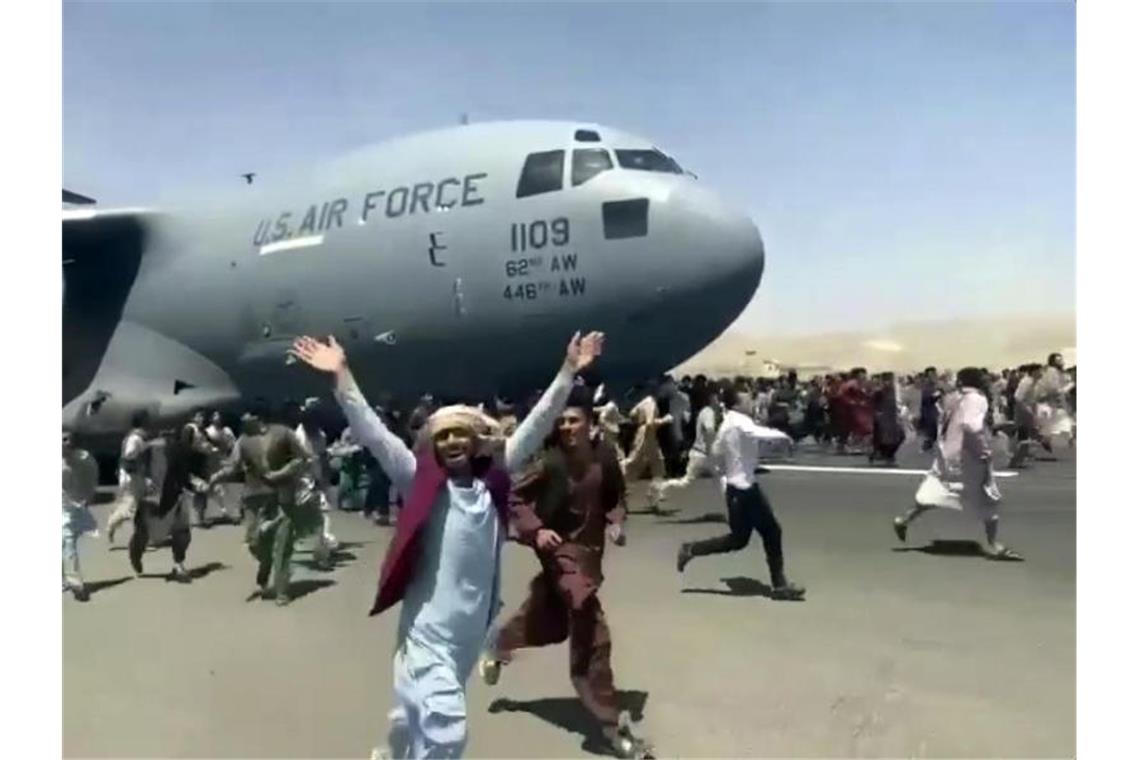 Zahlreiche Menschen sind auf dem Rollfeld des Kabul International Airport unterwegs. Foto: Uncredited/Verified UGC/AP/dpa