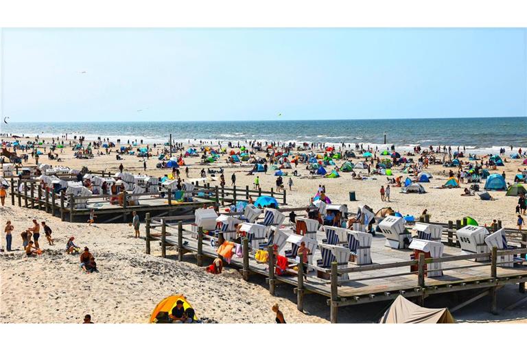 Zahlreiche Menschen sind bei strahlendem Sonnenschein am Strand von St. Peter Ording an der Nordsee unterwegs. (Archivbild)