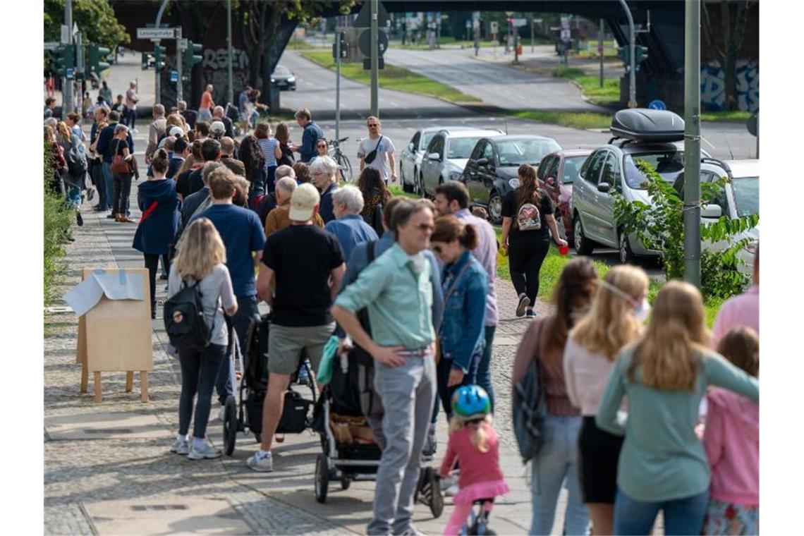 Zahlreiche Menschen stehen in einer langen Schlange vor den Wahllokalen im Tiergarten Gymnasium in der Altonaer Straße. Foto: Monika Skolimowska/dpa-Zentralbild/dpa