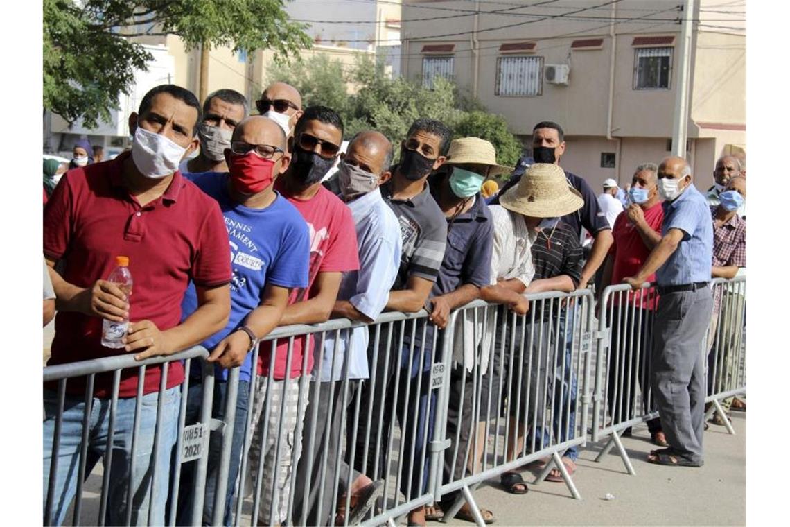 Wie die Massenimpfung in Tunesien auch dem Präsidenten nutzt Zahlreiche Menschen stehen vor einem Impfzentrum im tunesischen Oued Ellil Schlange. Foto: Hassene Dridi/AP/dpa