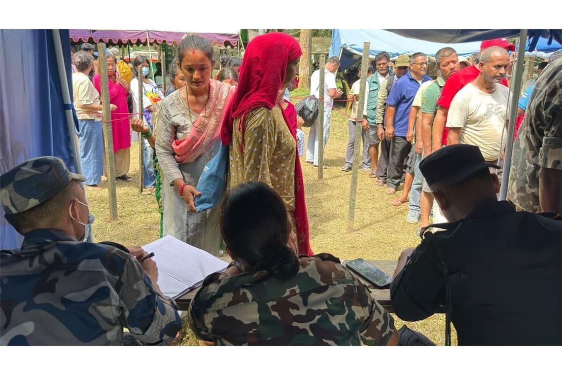 Zahlreiche Personen, die aus einem durch die Sturzflut abgeschnittenen Gebiet gerettet wurden, stehen in einem Armeelager im nepalesischen Distrikt Nuwakot Schlange, um sich registrieren zu lassen. 