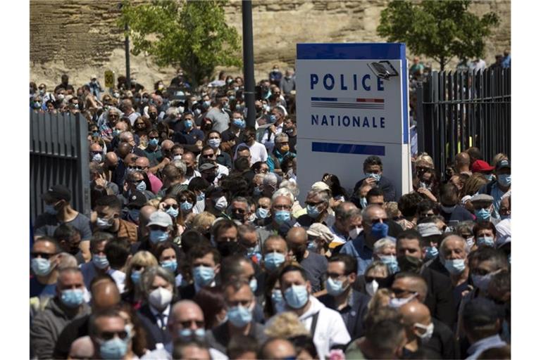 Zahlreiche Polizeibeamte und Zivilisten versammeln sich an einer Polizeistation, um dem getöteten Polizisten zu gedenken. Foto: Daniel Cole/AP/dpa