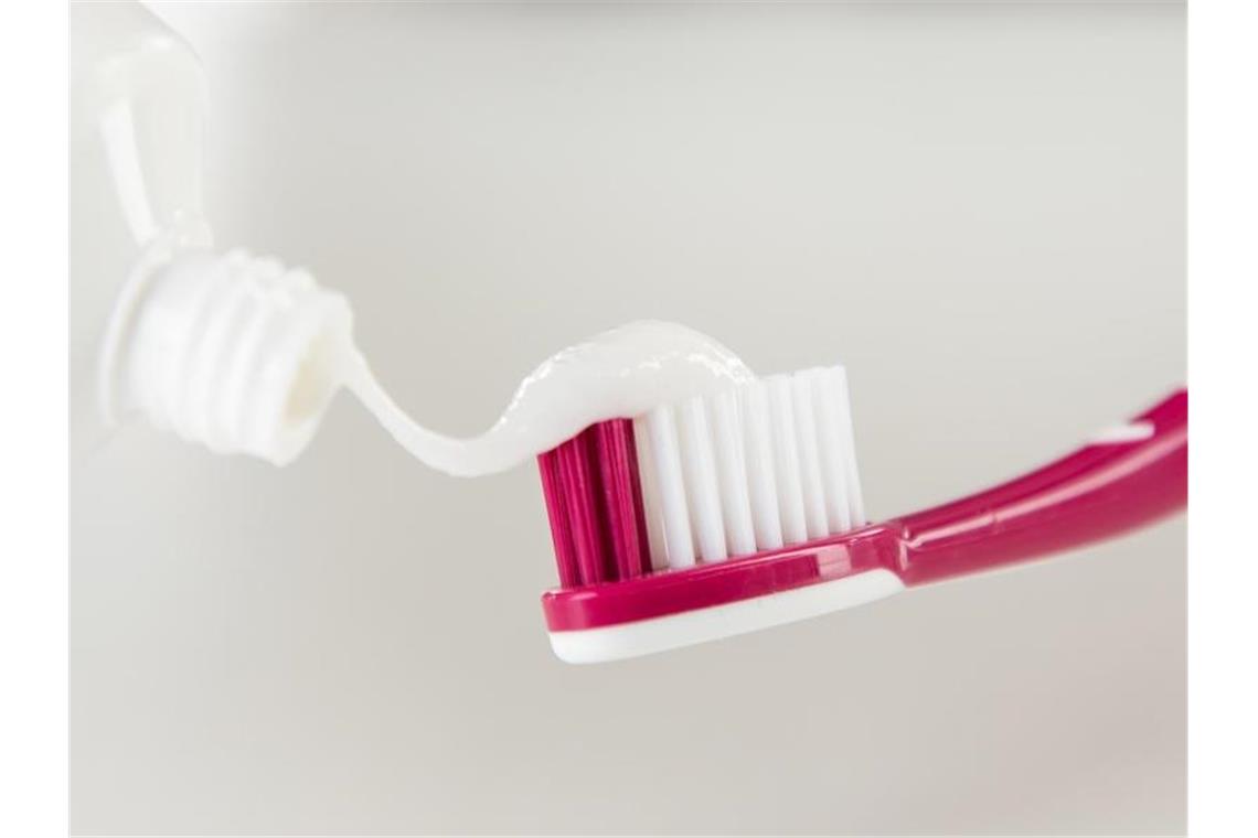 Zahnpasta wird auf eine Zahnbürste aufgetragen. Foto: Christin Klose/dpa-tmn/Illustration