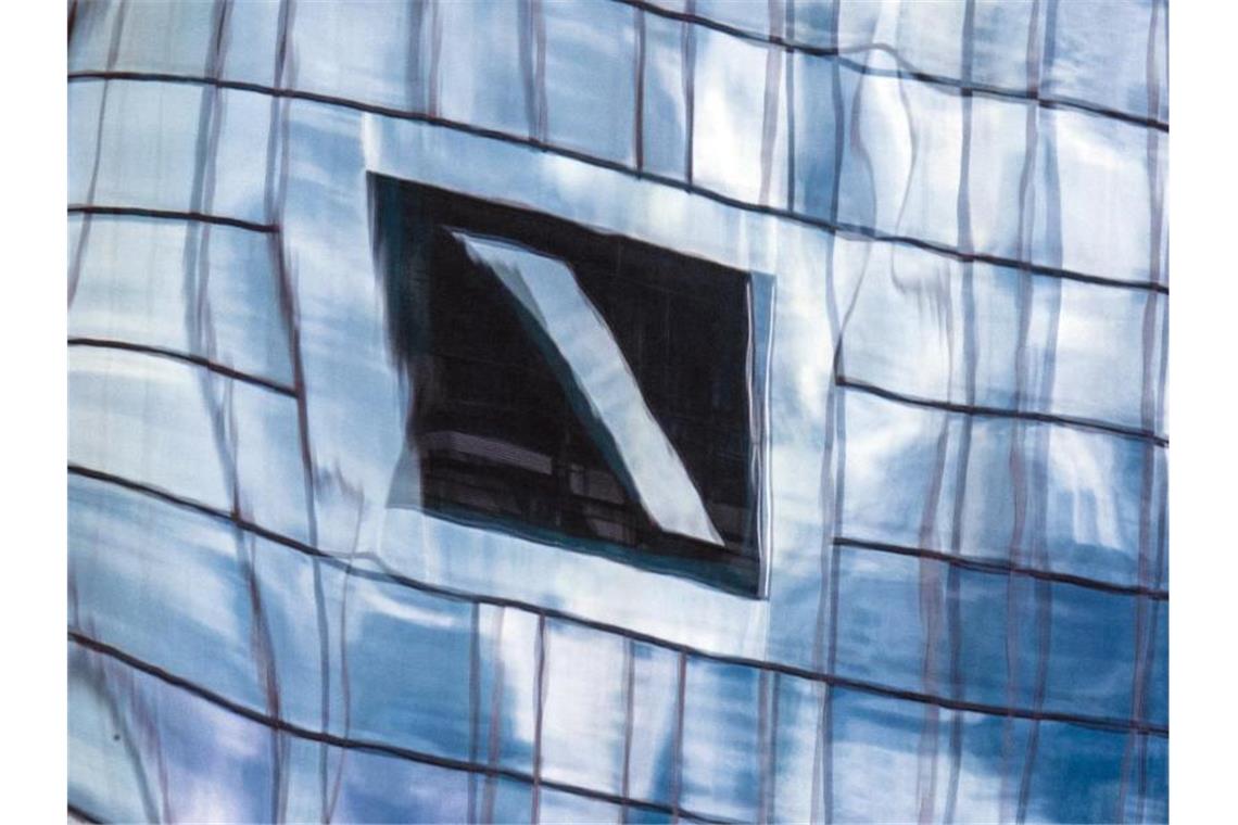 Zentrale der Deutschen Bank in einer Glasfassade gespiegelt. Insgesamt rund 70.000 Privatkunden der Deutschen Bank können derzeit ihre Kredite nicht bedienen. Foto: Boris Roessler/dpa