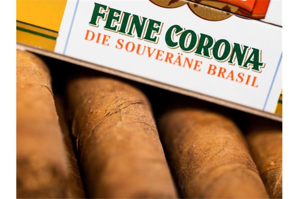 Autos, Bier und Zigarren - Wer „Corona“ alles im Namen trägt Zigarren im Format "Feine Corona" liegen in einer Schachtel in einem Tabakgeschäft. Foto: Rolf Vennenbernd/dpa