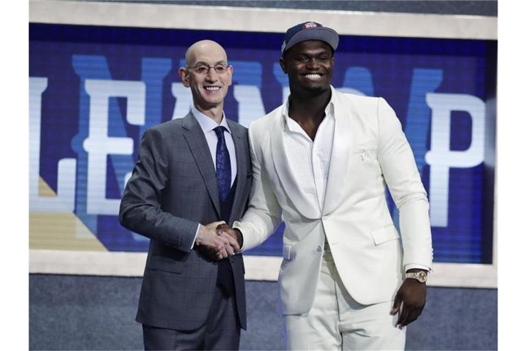 Zion Williamson (r) wird von NBA-Commissioner Adam Silver in der besten Basketballliga der Welt begrüßt. Foto: Julio Cortez/AP