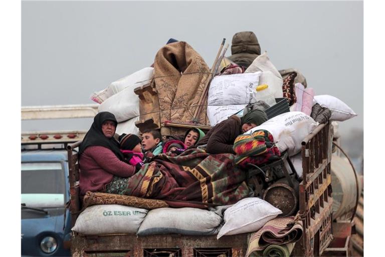 Zivilisten auf der Ladefläche eines Fahrzeugs bei der Flucht aus Idlib. Foto: Ugur Can/DHA/dpa