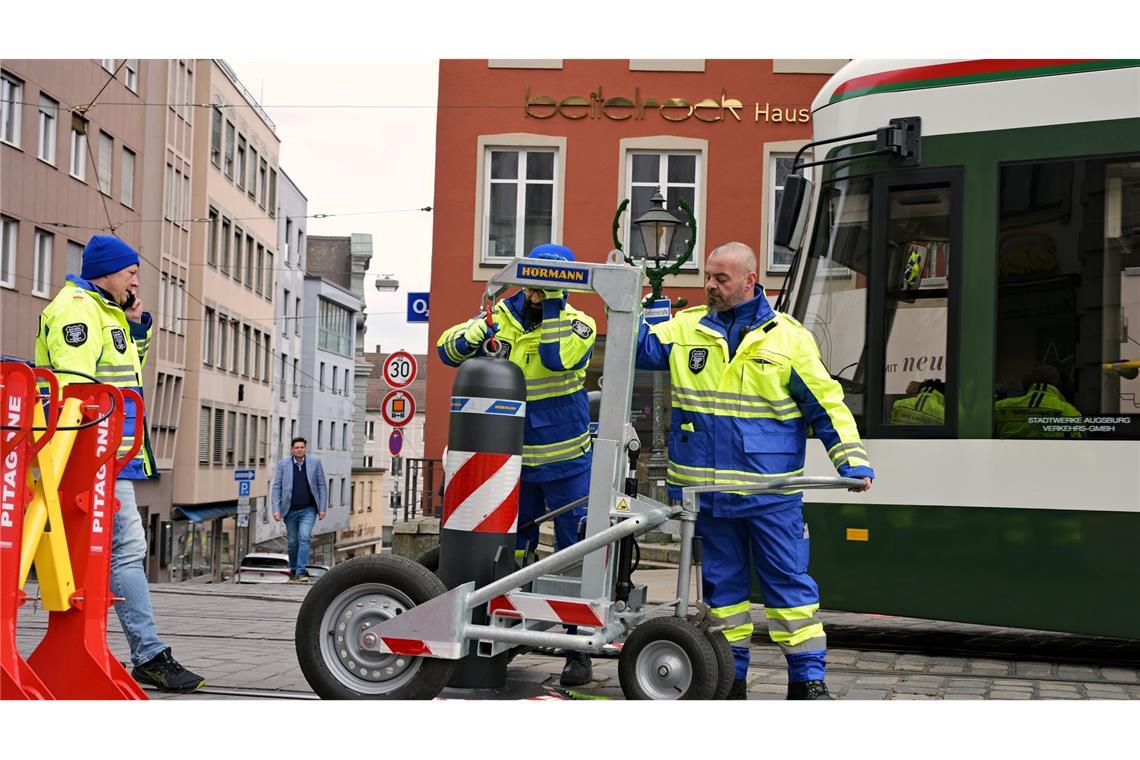 Zu den Hauptverkehrszeiten müssen Sicherheitsmitarbeiter neben dem Augsburger Christkindlesmarkt jede Stunde dutzendfach schwere Poller bewegen, damit die Straßenbahnen durchfahren können.