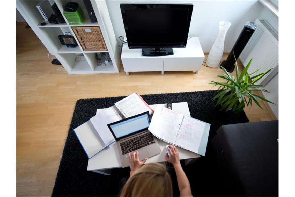 Zu Hause statt im Büro: Eine Frau arbeitet in einem Wohnzimmer an einem Laptop. Foto: Daniel Naupold