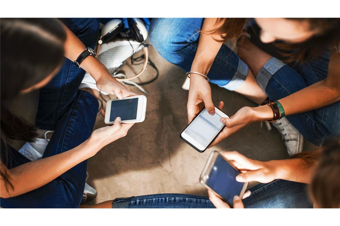 Gefangen in der Hölle des Digitalen Zu viel online? Eine Gruppe junger Mädchen schaut aufs Handy.