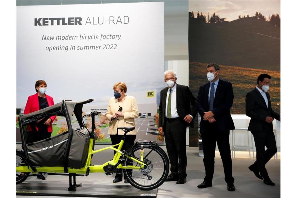 Zukunft der Mobilität? VDA-Präsidentin Hildegard Müller (l-r), Kanzlerin Angela Merkel sowie die Regierungschefs von Baden-Württemberg und Bayern, Winfried Kretschmann und Markus Söder, neben einem Cargo-E-Bike an. Foto: Michaela Rehle/Reuters/Pool/dpa