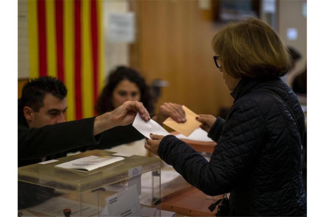 Zum zweiten Mal in diesem Jahr: Eine Wählerin nimmt in Barcelona ihren Stimmzettel für die Parlamentswahl entgegen. Foto: Emilio Morenatti/AP/dpa