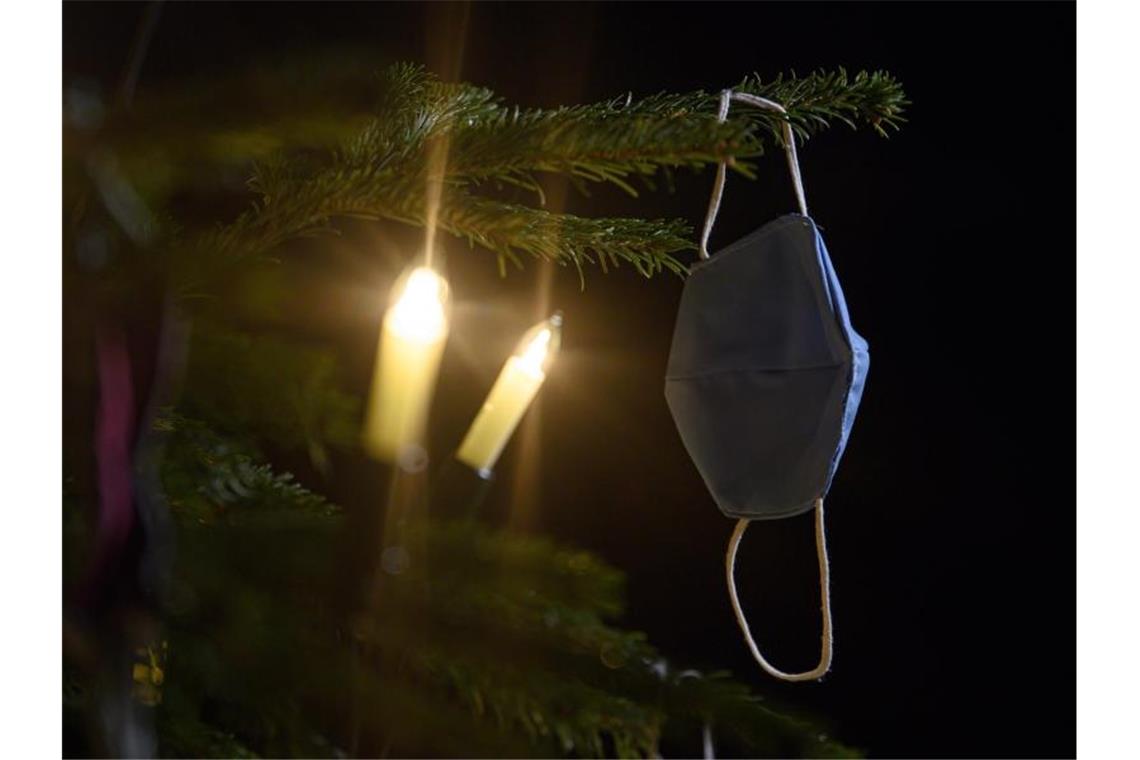 Umfrage: Corona sorgt für Familienzoff Zur Sicherheit lieber mit Maske: Weihnachten findet schon zum zweiten Mal unter den Bedingungen der Corona-Pandemie statt. Foto: Robert Michael/dpa-Zentralbild/dpa
