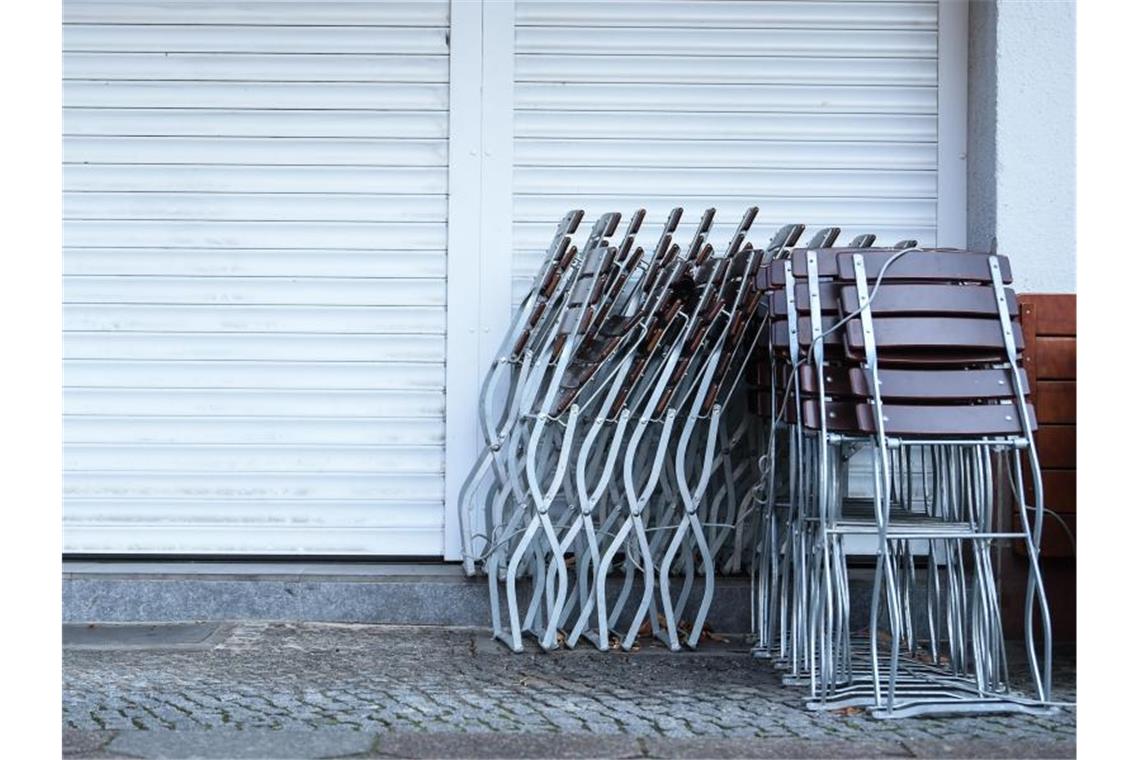 Zusammengestapelte Stühle vor einem geschlossenen Geschäft. Foto: Kira Hofmann/dpa-Zentralbild/dpa/Symbolbild/Archiv