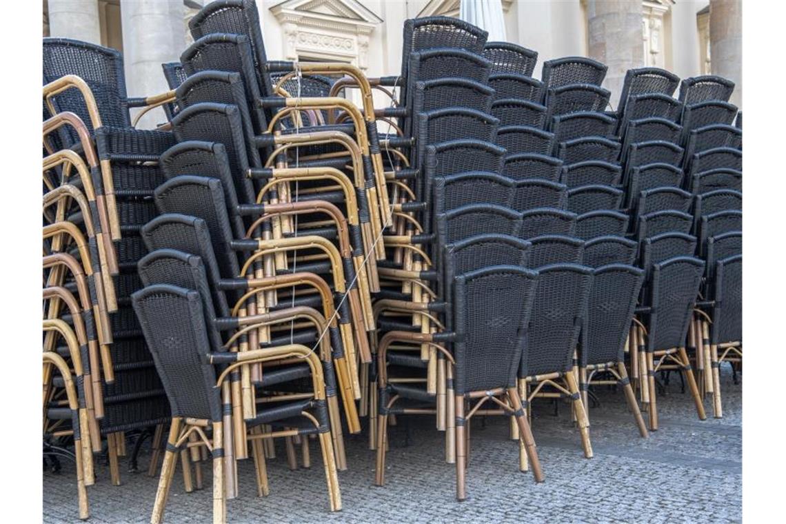 Zusammengestellte Stühle stehen vor einem gastronomischen Betrieb in Potsdam. Foto: Paul Zinken/dpa-Zentralbild/dpa