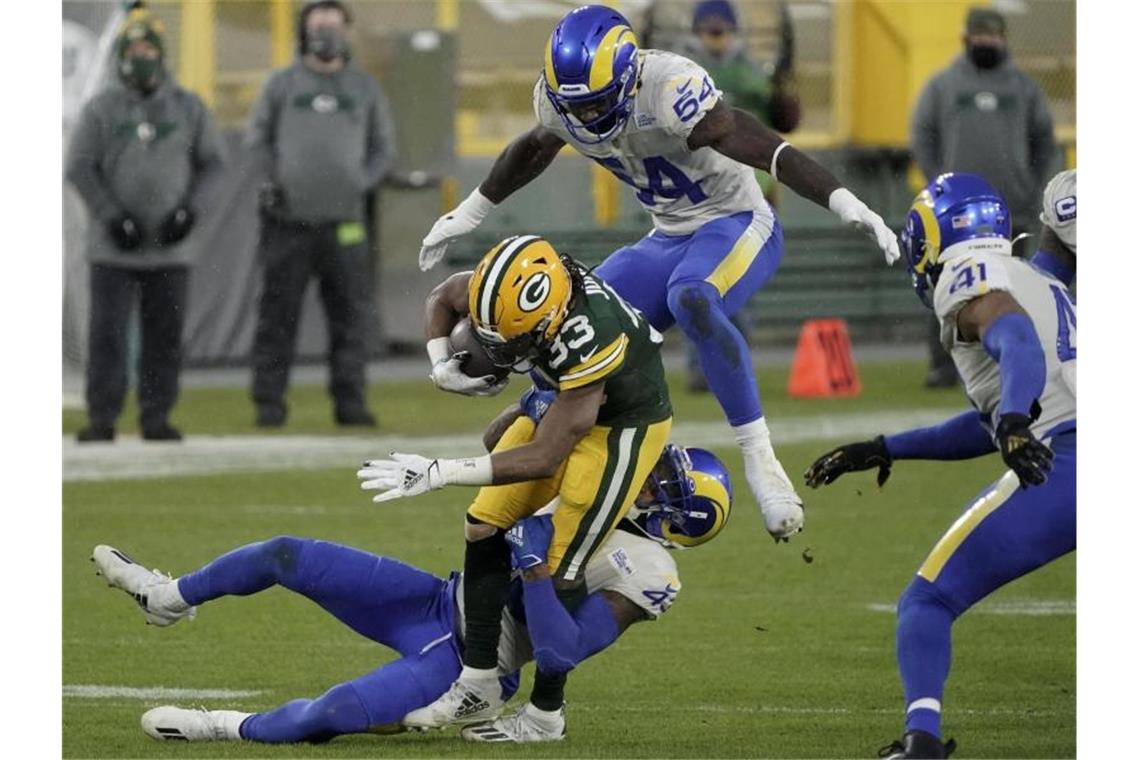 Green Bay Packers und Buffalo Bills in NFL-Playoffs weiter Zusammenstoß: Leonard Floyd (54) von den Los Angeles Rams springt über Aaron Jones (33) von den Green Bay Packers, als dieser von Nick Scott von den Los Angeles Rams geblockt wird. Foto: Morry Gash/AP/dpa