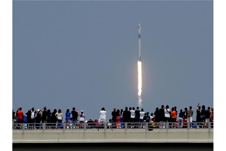 Zuschauer beobachten den Start der „Falcon 9“-Rakete vom Weltraumbahnhof Cape Canaveral. Foto: Charlie Riedel/AP/dpa