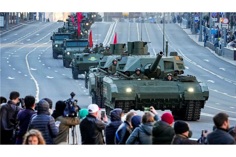 Zuschauer beobachten im Mai 2022, wie ein russischer T-14 Armata-Panzer (im Vordergrund) und andere gepanzerte Fahrzeuge auf der Twerskaja-Straße in Richtung Roter Platz rollen.
