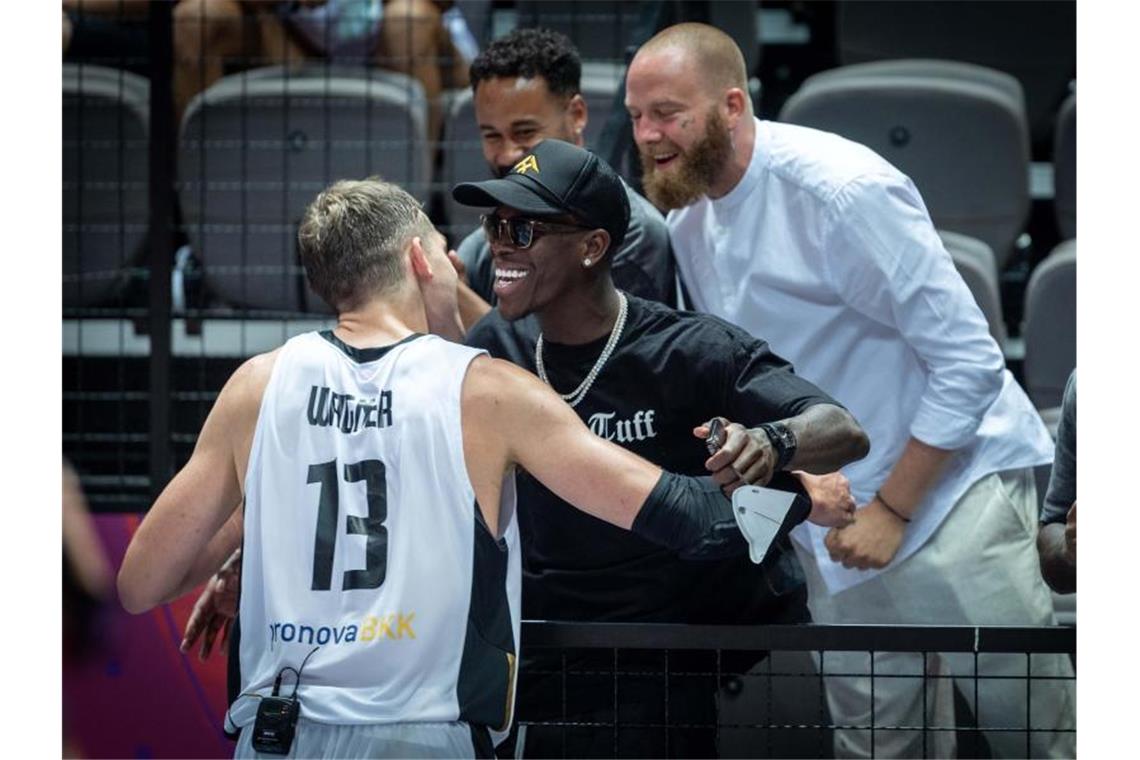 DBB-Team feiert rauschende Party - Rätselraten um Schröder Zuschauer Dennis Schröder (M) beglückwünscht Moritz Wagner (l) nach der erfolgreichen Olympia-Qualifikation. Foto: Tilo Wiedensohler/dpa