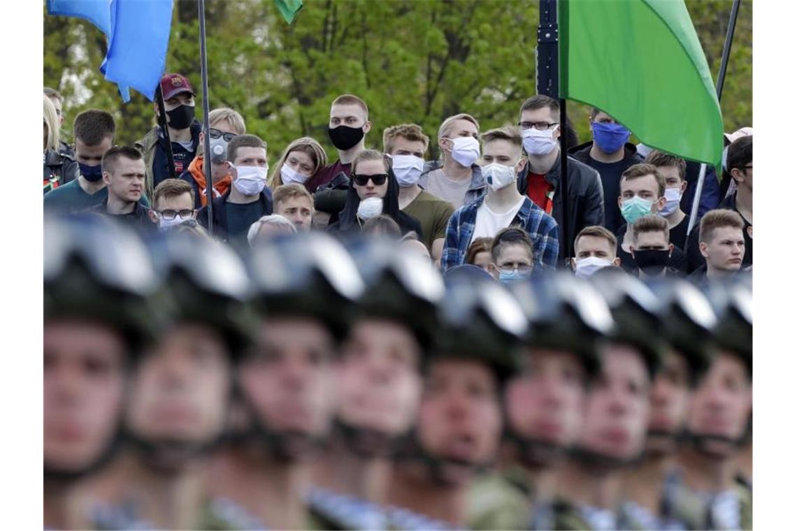 Zuschauer verfolgen in Minsk die Militärparade. Foto: Sergei Grits/AP/dpa