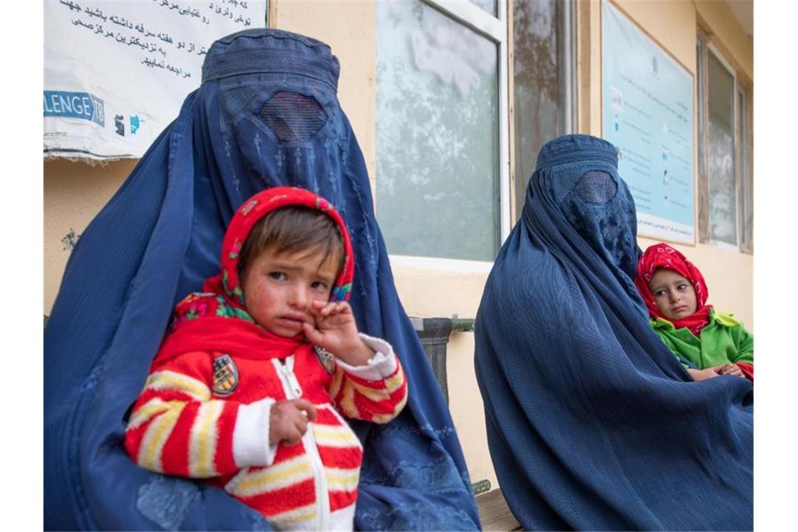 Zwei afghanische Frauen warten mit ihren Kindern vor einer Klinik für Ernährungsfragen. Foto: Julian Frank/WFP/dpa